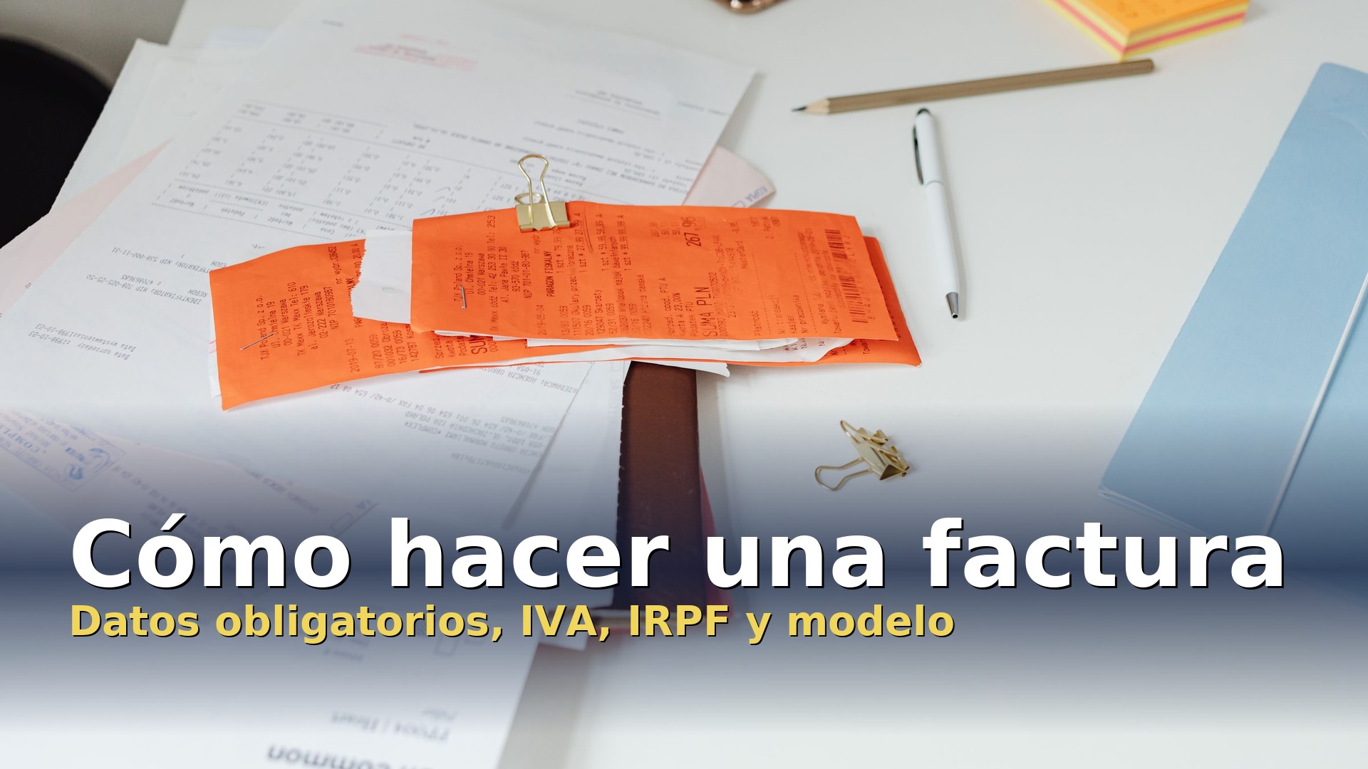 Cómo hacer una factura: facturas y tickets sobre una mesa con bolígrafo